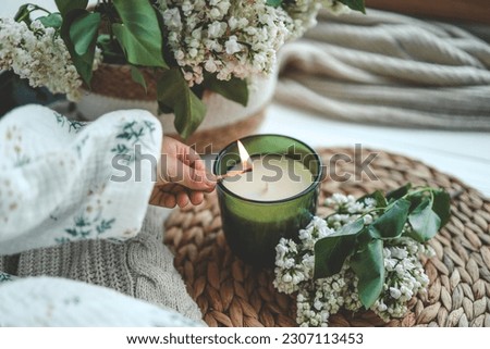 Match in hand lighting candles, aesthetics. Royalty-Free Stock Photo #2307113453