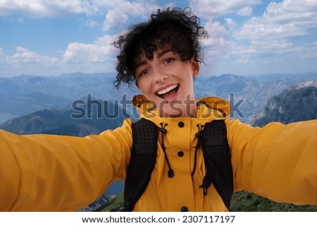 Happy woman taking selfie in beautiful mountains