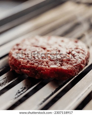 100% beef burgers on the griddle in a cafeteria

