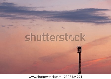 Silhouettes telecommunication tower at sunset. Beautiful sky.