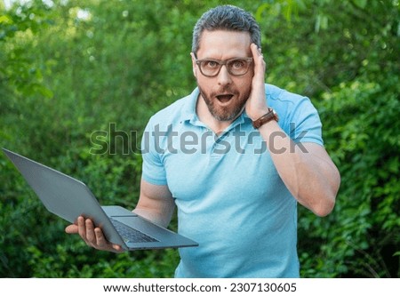 surprised programmer man working online on laptop. photo of programmer man online on computer