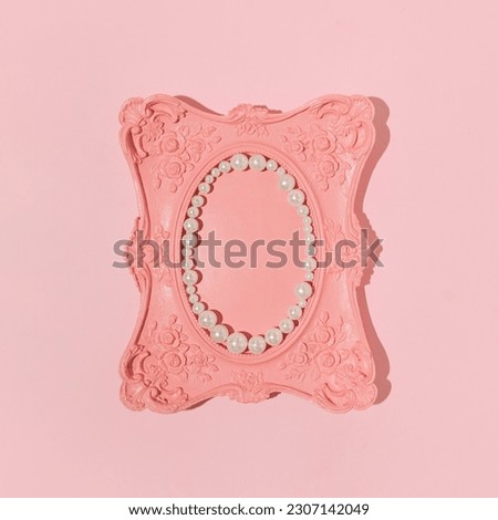 Creative aesthetic romantic retro style frame against pastel pink background, oval shaped copy space decorated with pearl beads.