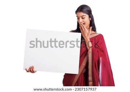 Exited Indian woman in traditional saree holding sign board isolated on white. advertisement concept. 