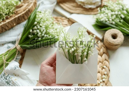 Envelope with lilies of the valley and aesthetic decor, holiday concept.