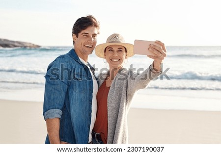 Young couple, beach selfie and smile in summer sunshine for love, romance or happy for social media post. Man, woman and profile picture for blog, app or internet by ocean, waves or sea for vacation