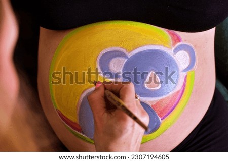 hand painting pregnant belly. Baby shower and bellypainting