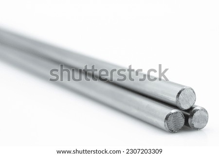 Three Stainless steel metals bars against white background with tiny reflection shot from an angle. Long.  Royalty-Free Stock Photo #2307203309