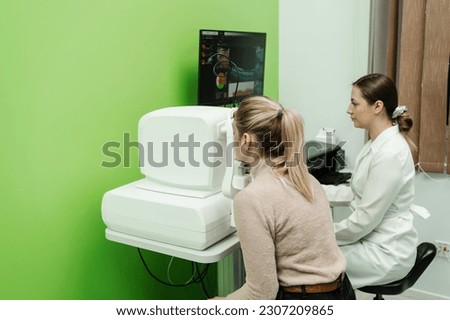 Optical coherence tomography OCT scan to create pictures of the back of eye. Examination of eyes of patient using optical coherence tomograph. Ophthalmologist is scanning cornea of woman patient