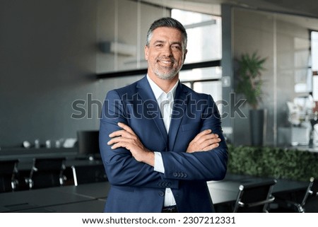 Happy mid aged business man ceo standing in office arms crossed. Smiling mature confident professional executive manager, proud lawyer, confident businessman leader wearing blue suit, portrait. Royalty-Free Stock Photo #2307212331