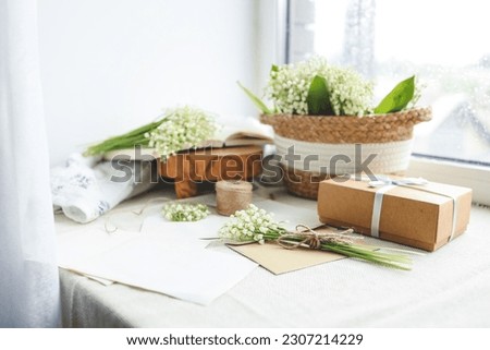 Festive concept, lily of the valley bouquet, gift box and letter.