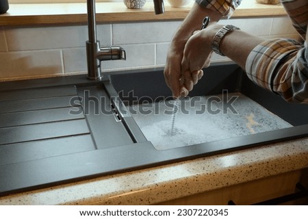 Overflowing kitchen sink, clogged drain, plumbing problems, trying to unclog Royalty-Free Stock Photo #2307220345