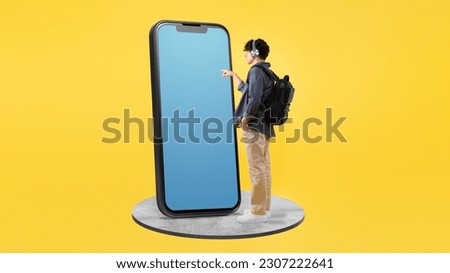 Mobile Innovation. Student Guy Showing Modern Smartphone Technology Touching Blank App Screen, Texting And Websurfing Posing With Backpack On Yellow Studio Background. Panorama, Mockup Royalty-Free Stock Photo #2307222641