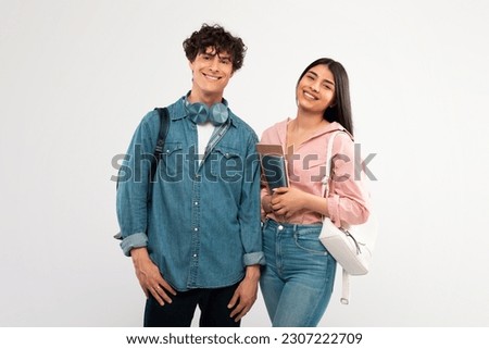 Youth And Friendship. Happy Students Couple Posing With Backpack And Textbooks Smiling To Camera Hugging Over White Studio Background. Shot Of Cheerful College Friends Duo Royalty-Free Stock Photo #2307222709