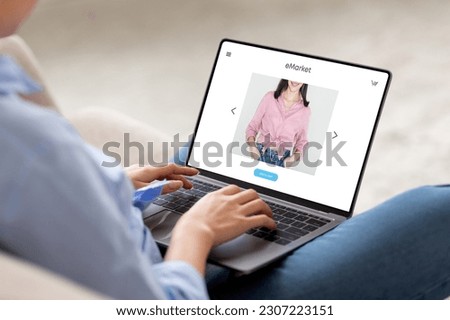 Young european woman sit on couch at home, using modern laptop for surfing in internet, enjoy online shopping, with fashion website store on screen, cropped. Shopaholic order clothes at home Royalty-Free Stock Photo #2307223151