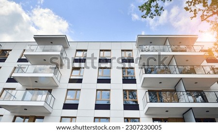 Eco architecture. Green tree and new apartment building. The harmony of nature and modernity. Modern residential building with new apartments in a green residential area.  Royalty-Free Stock Photo #2307230005