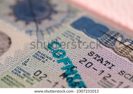 close-up part of page of document, foreign passport for travel with European visa, tourist schengen visa stamp with hologram with shallow depth of field, passport control at border, travel in Europe