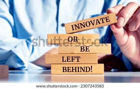Close up on businessman holding a wooden block with the "Innovate or be left behind" message