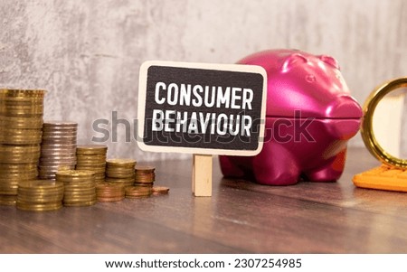mini black board with text consumer behaviour isolated on wooden background