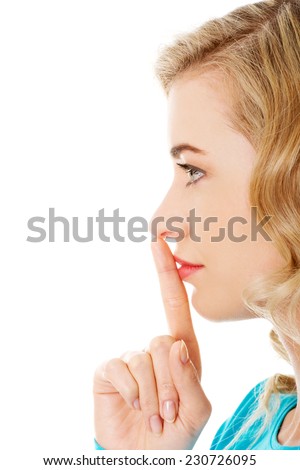 Side view of a woman making silence gesture.