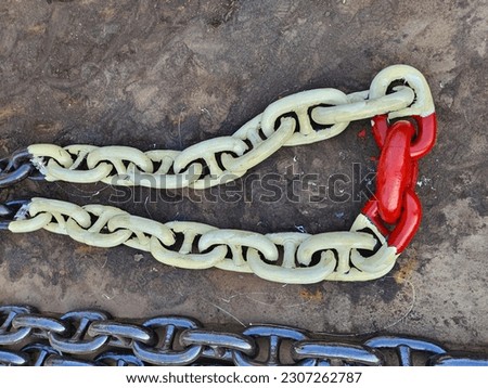 An anchor chain of a cargo ship marked with paint laying on ground