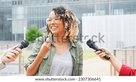 African woman being interviewed on the street by the media. Royalty-Free Stock Photo #2307306641