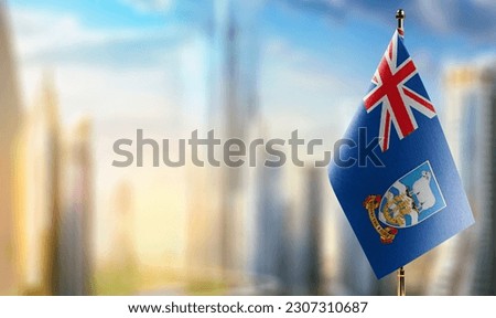 A small Falkland Islands flag on an abstract blurry background.