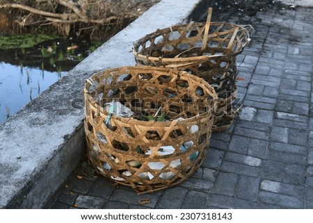 a basket made of bamboo which is used as a trash can