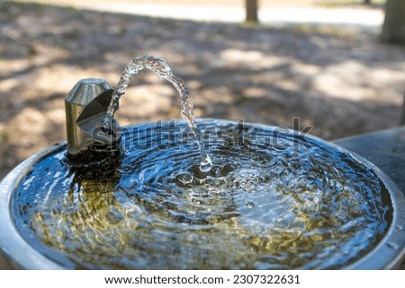 Stainless steel water fountain in public park Royalty-Free Stock Photo #2307322631