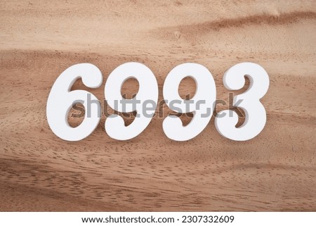 White number 6993 on a brown and light brown wooden background.