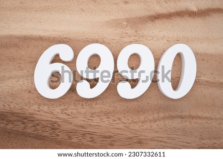 White number 6990 on a brown and light brown wooden background.