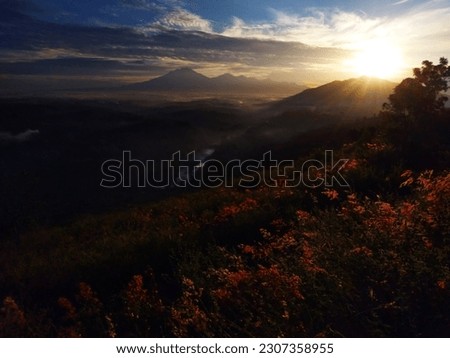 photo of sunrise in indonesia with beautiful mountain view and multi coloured background