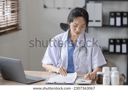 Young asian female medical doctor working at desk in a hospital, healthcare and medical concept.