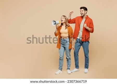 Full body young couple two friends family man woman wears casual clothes together hold megaphone scream announces discounts sale Hurry up do winner gesture isolated on pastel plain beige background