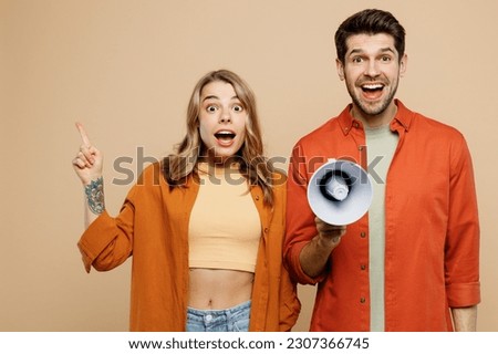 Young couple two friends family man woman wear casual clothes hold in hand megaphone scream announces discounts sale Hurry up together point aside isolated on pastel plain light beige color background Royalty-Free Stock Photo #2307366745