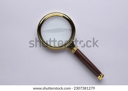 Magnifying glass on light grey background, top view