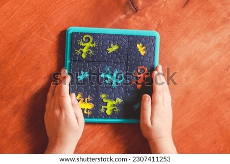 educational and logical children's game on a wooden surface in the hands and the child during the game selective focus