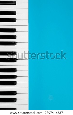 Flat lay background with piano, white synthesizer on blue background, musical keys isolated, top view, copy space.