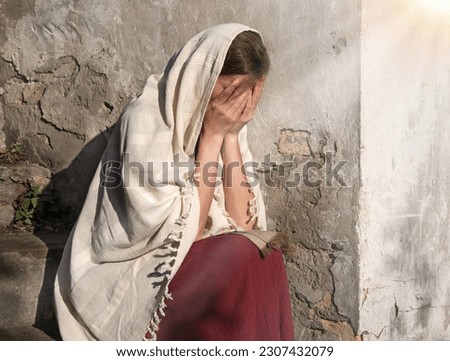 Misery lost feel mourn weep mood young lone holy jew maid slave teen lady Mary sit ask god Jesus Christ faith hope. Old retro roman history biblical adult human shame abuse white islam home text space Royalty-Free Stock Photo #2307432079