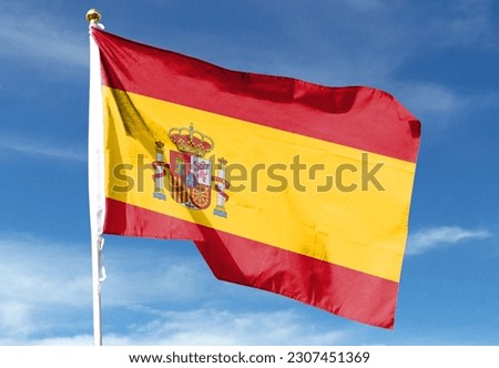 Spanish flag in the cloudy sky. waving in the sky Royalty-Free Stock Photo #2307451369