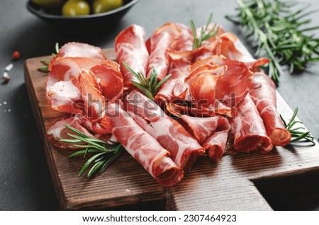 Cured Meat Platter, Antipasto, Appetizer on a Boardover Dark Background Royalty-Free Stock Photo #2307464923