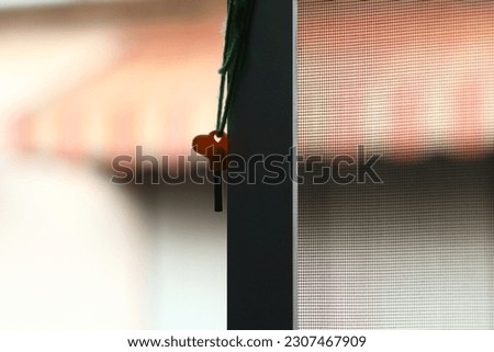 Hanging key with string at the window on the defocus background.