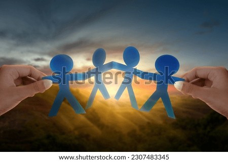 Human hand showing paper people are holding hands symbol of friendship. International friendship day concept