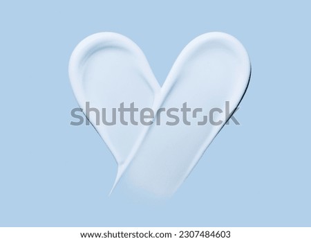 Heart shaped cosmetic smear of cream on a blue background Royalty-Free Stock Photo #2307484603