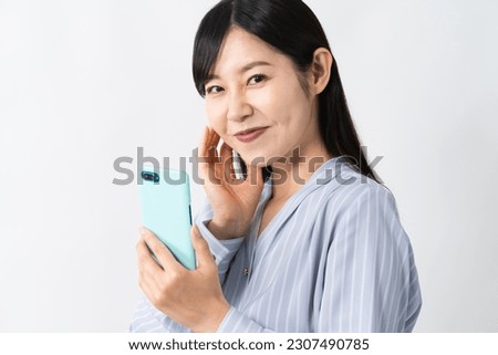 Young woman thinking while holding a smartphone