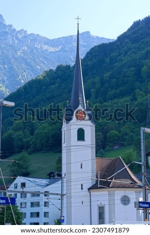 Scenic view of Swiss village of Flüelen with catholic church on a sunny spring morning. Photo taken May 22nd, 2023, Flüelen, Canton Uri, Switzerland.