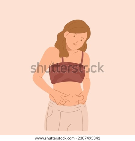 Young sad woman grabbing her fat on the stomach. Royalty-Free Stock Photo #2307495341