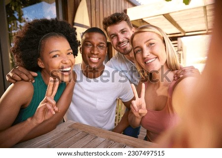 POV Shot Of Multi-Cultural Friends Posing For Selfie On Mobile Phone Outdoors At Home Royalty-Free Stock Photo #2307497515