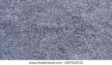 Black felt material. Surface of felted fabric texture abstract background in dark gray color. 