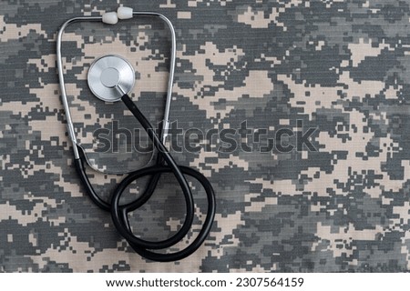 Closeup of a doctors stethoscope laying on old Military camouflage background