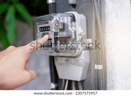 Hand is touching the transformer with copy space.Incorrect energy detection method.Watthour meter of electricity for use in home appliance.Electronics Royalty-Free Stock Photo #2307575957